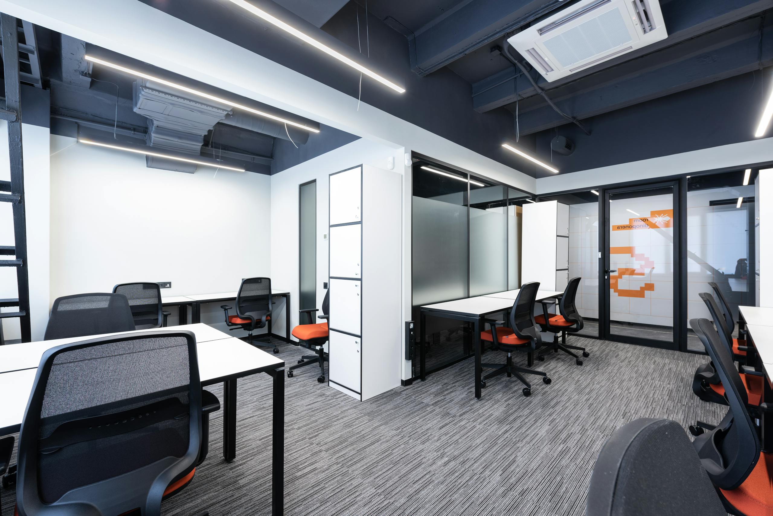 Spacious and modern office interior with sleek furniture and bright lighting.